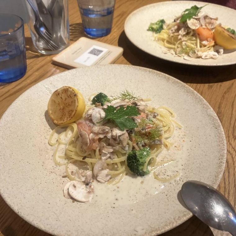 白い器に盛られたスモークサーモンとキノコのクリームパスタ