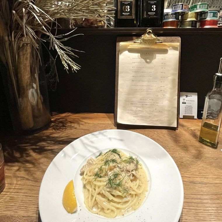 テーブルに並んだ白い器に盛られたパスタとメニュー