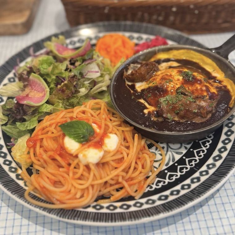 トマトソースパスタとサイコロステーキ、彩り豊かなサラダが添えられたランチプレート