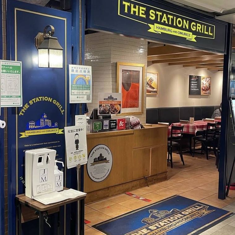 青い外壁に黄色いロゴのザ・ステーショングリル外観