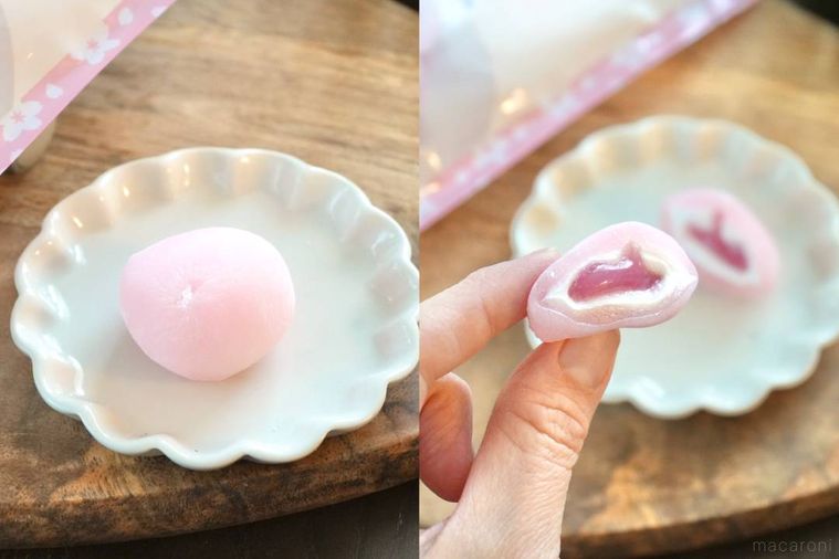 木のカッティングボードと白い小皿にのったさくらラテ大福を手に持つ様子