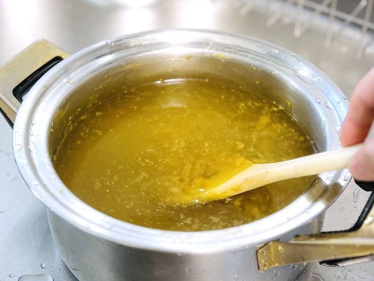 鍋にこびりついたカレーをヘラでこすっている様子