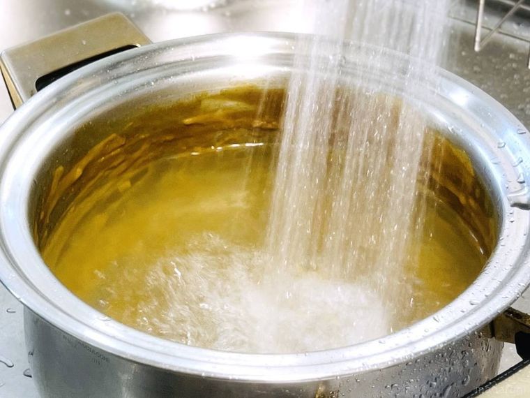 カレーがこびりついた鍋にお湯をかけている様子