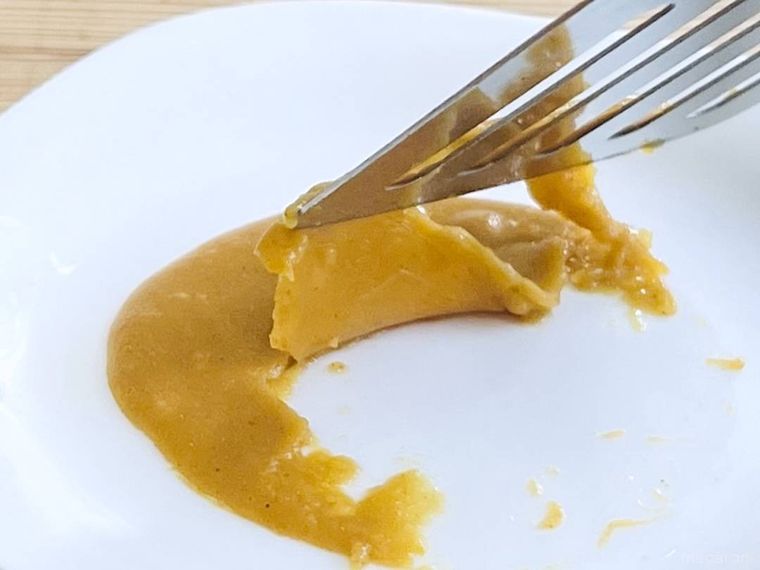 皿にこびりついたカレーをヘラで剥がしている様子