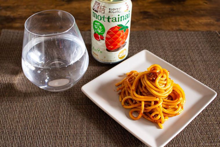 キリンキリン 氷結モッタイナイ なごりいちごの缶と中身を注いだグラス、お皿に盛ったボロネーゼがテーブルに並んでいる