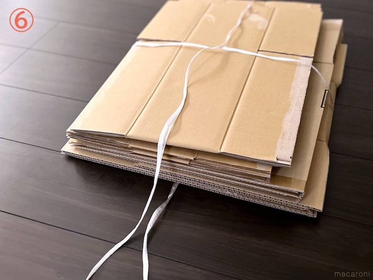 ダンボールをヒモで束ねている様子