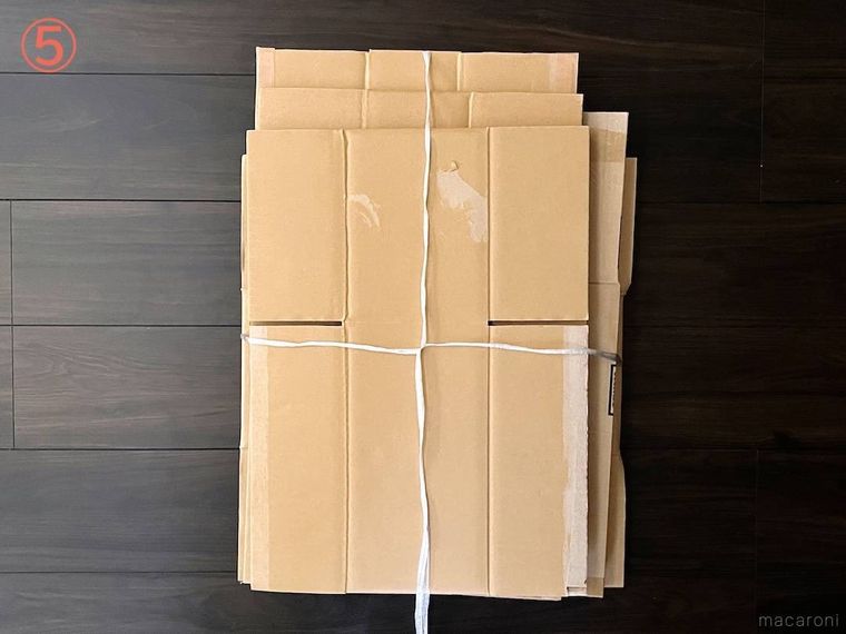 ダンボールをヒモで束ねている様子