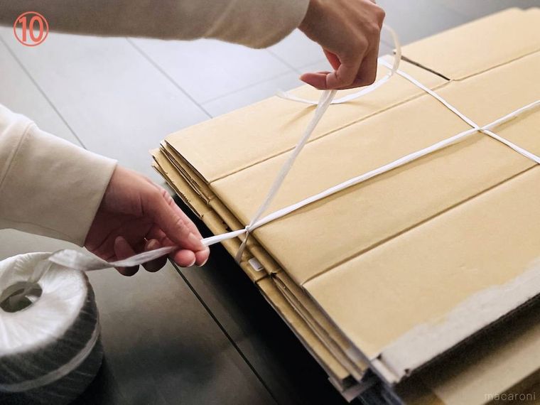 ダンボールをヒモで束ねている様子