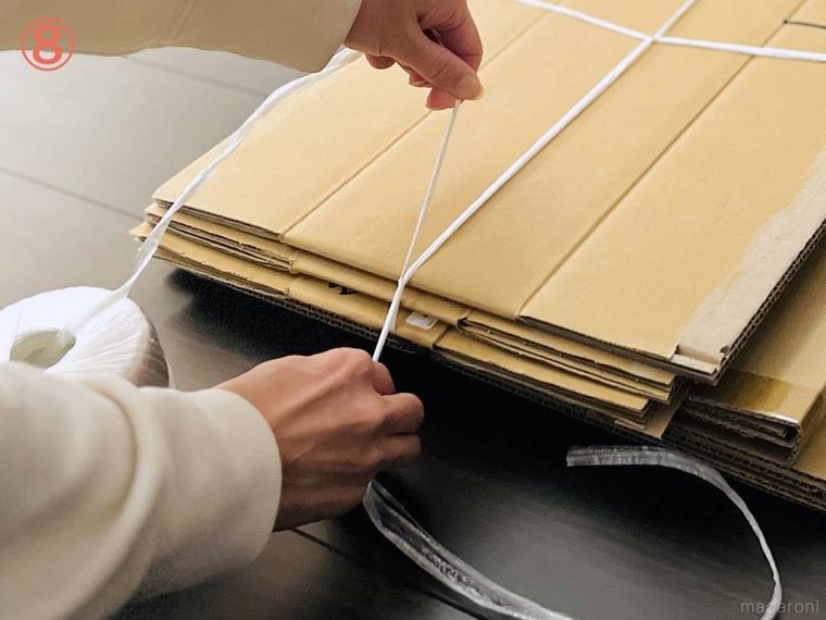 ダンボールをヒモで束ねている様子