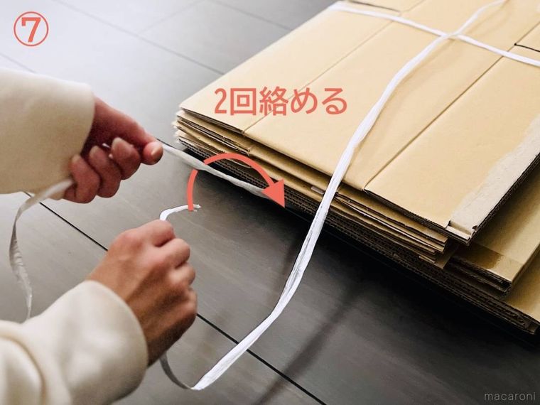 ダンボールをヒモで束ねている様子