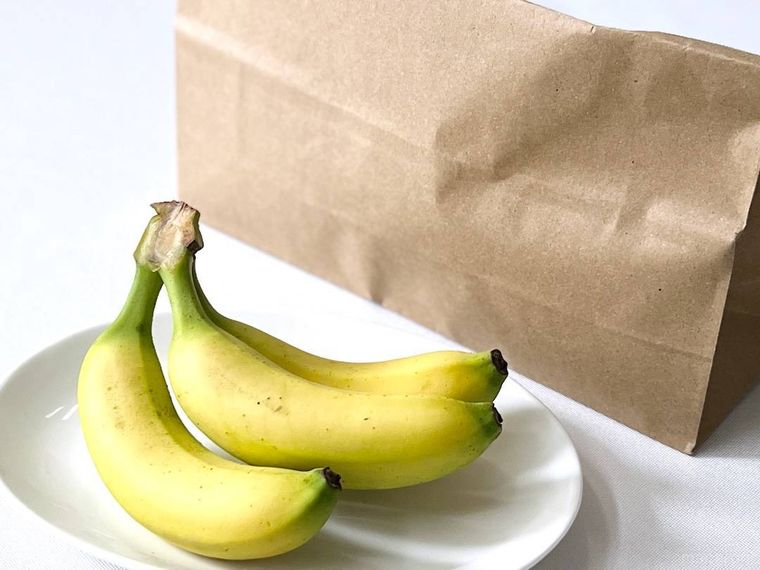 バナナが入った紙袋と、バナナがのった白い皿