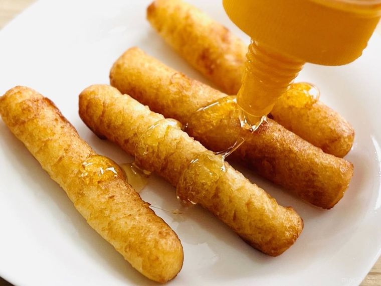 もちもちポテトフライにはちみつをかけている様子