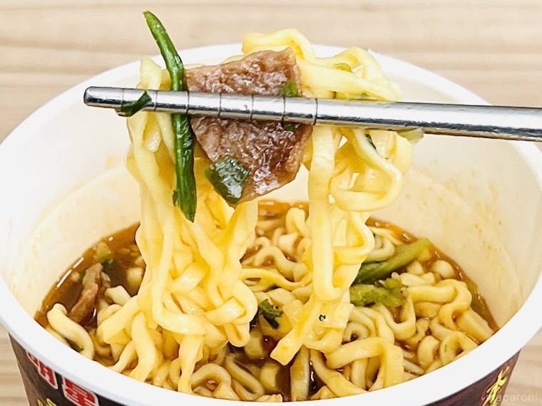 明星 麻膳堂監修 麻辣牛だし麺の麺と具を箸で持ち上げている様子