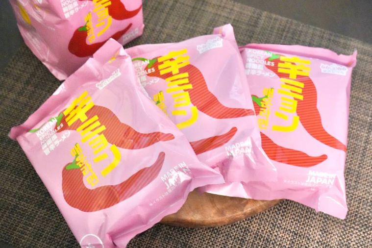 木のカッティングボードにのった3袋のインスタントラーメン