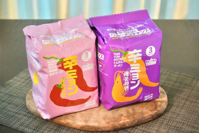 木のカッティングボードにのったカラフルなパッケージの辛いラーメン