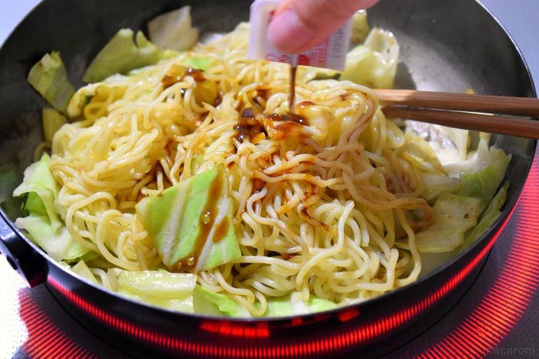 フライパンの中でカレーソースをかけた焼きそば