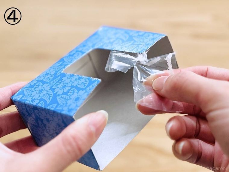 箱ティッシュの空箱のフィルムを剥がしている様子