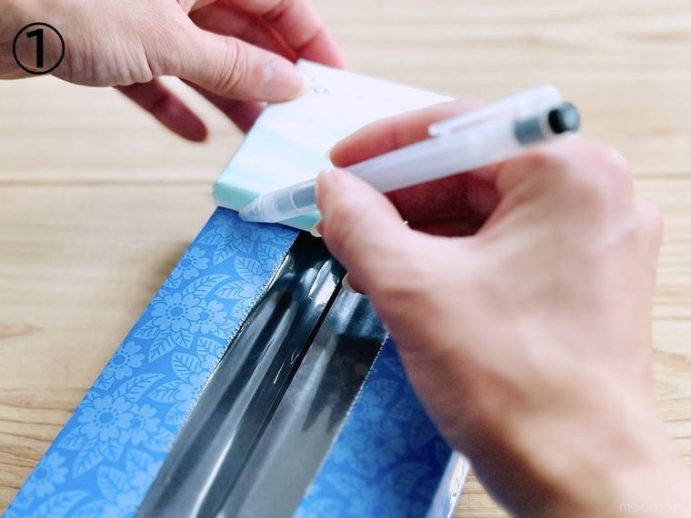 箱ティッシュの空箱にボールペンで印を付けている様子