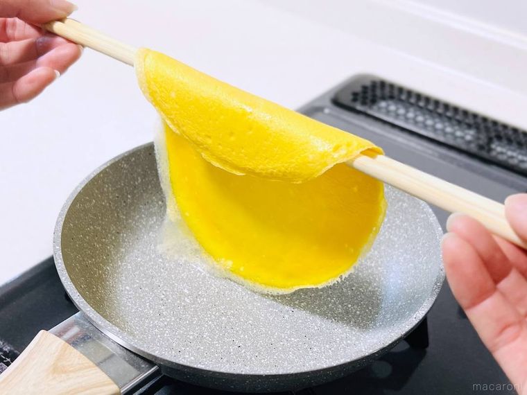 薄焼き卵を菜箸にかけて持ち上げている様子