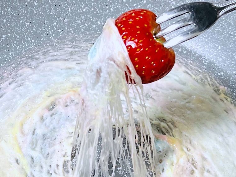 いちごに溶かしたマシュマロを絡めている様子