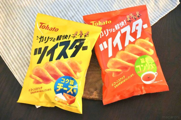 木のカッティングボードにのったオレンジ色と黄色のコーンスナックのパッケージ