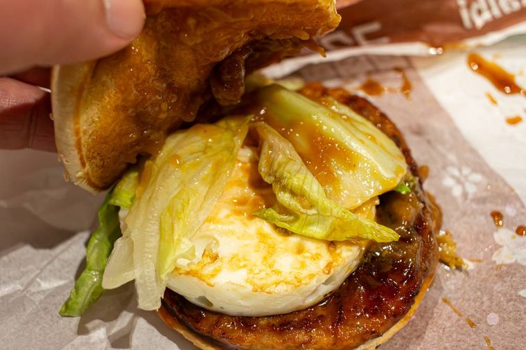 マクドナルドコク旨かるび焼肉風てりたまのバンズを持ち上げている様子