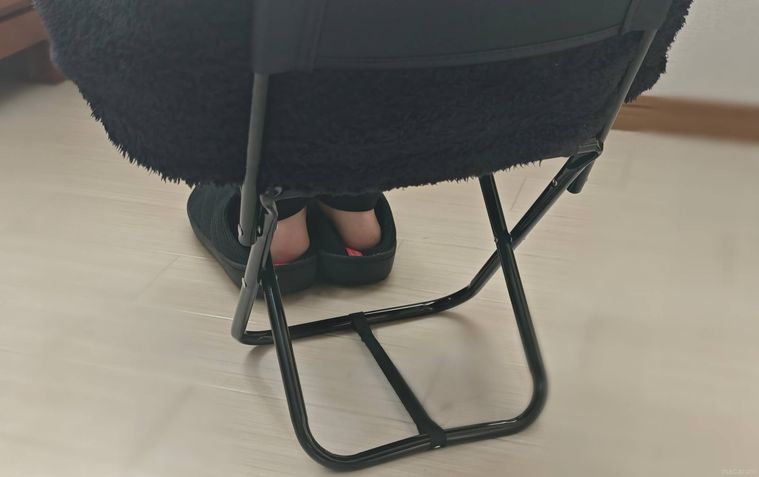 背もたれ付き折りたたみ椅子に座っている様子