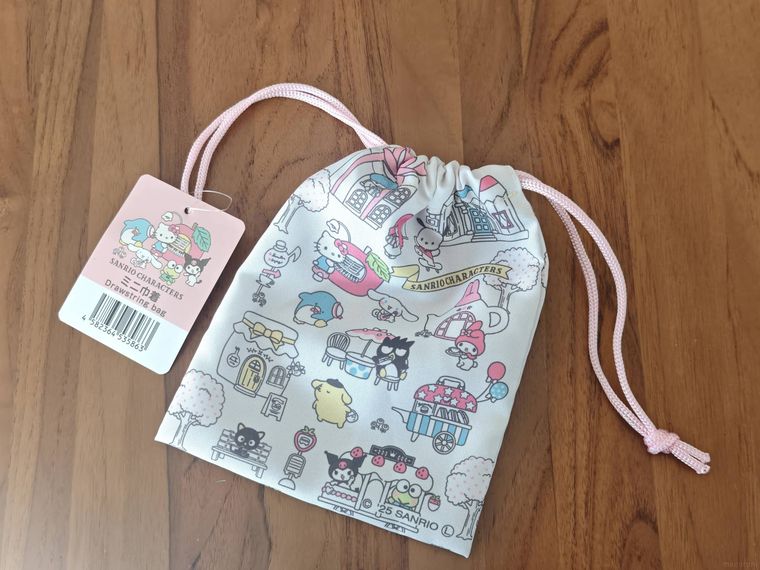 サンリオキャラクターズ ミニ巾着が机の上に置いてある