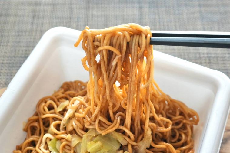 カップ焼きそばを黒い箸で持ち上げる様子