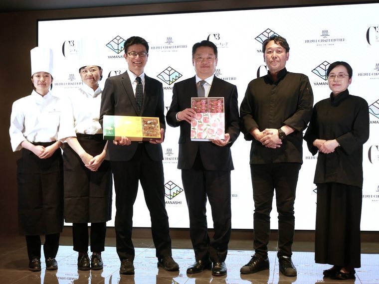 記者会見の壇上にいるスーツの人々