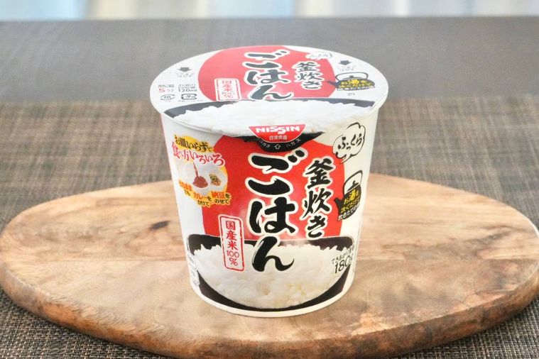 木のカッティングボードにのった白いカップのインスタントごはん