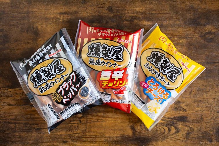 丸大食品燻製屋の旨辛チョリソー燻製ブラックペッパーとろける濃厚チーズが木製テーブルの上に並んでいる