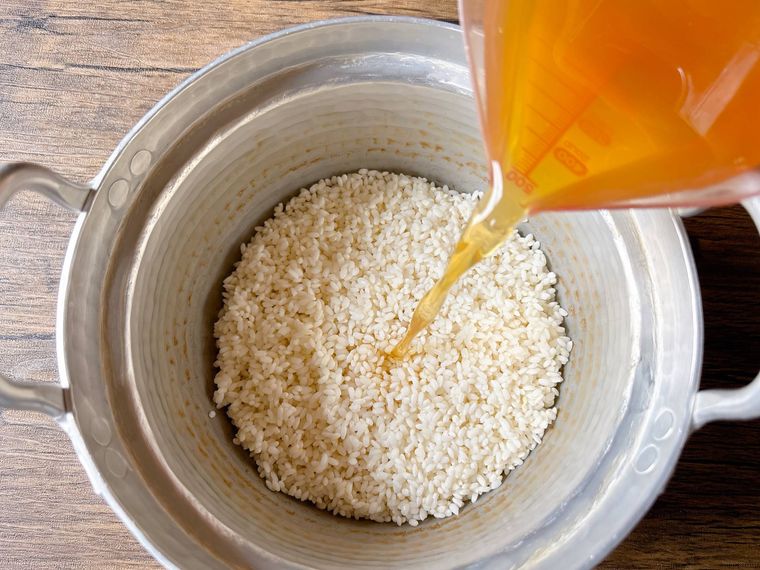 米に調味料と缶汁、水を合わせたものを入れる様子