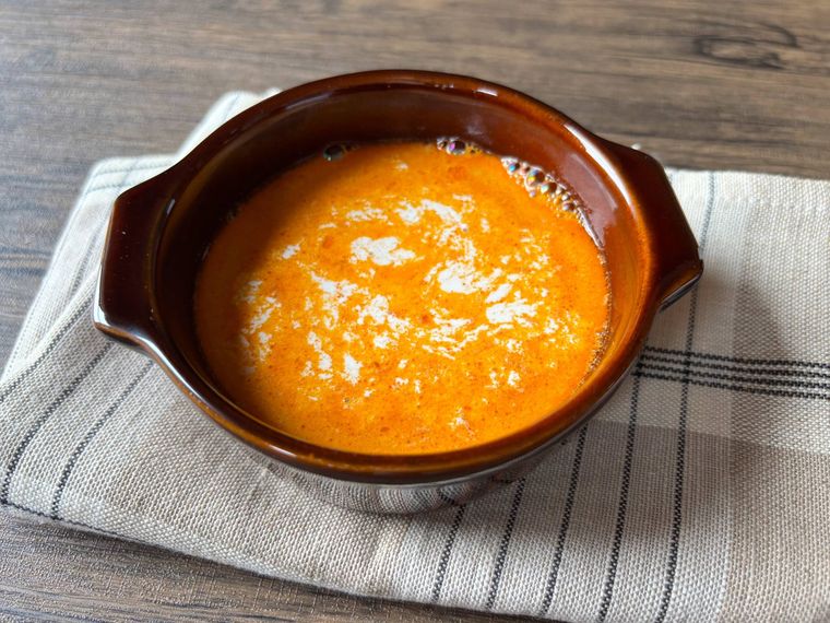 茶色のスープボウルに入った海老のビスクに生クリームを加えたもの