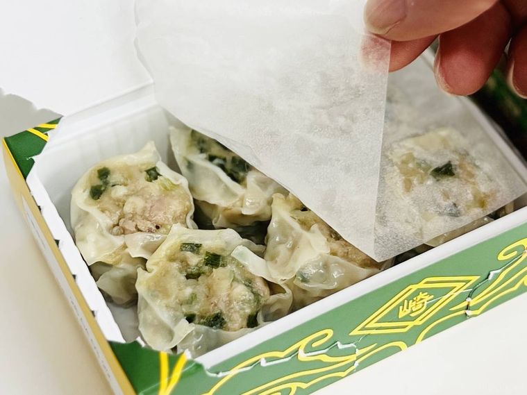 崎陽軒のギヨウザの中に入っている紙をめくっている様子