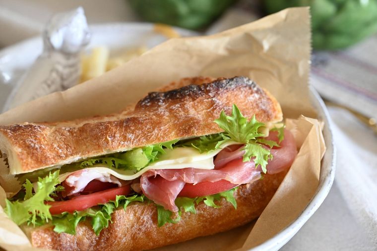 白い皿に盛られた生ハムとレタスのサンドイッチ