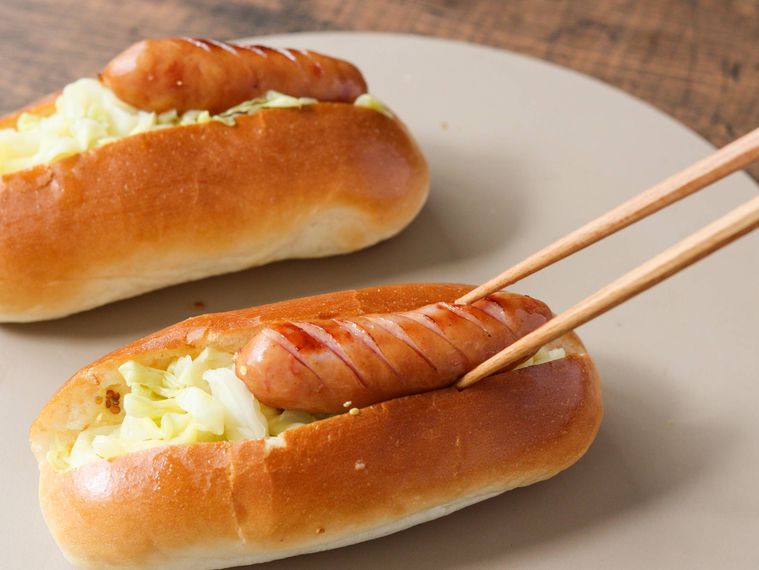 ロールパンに具材をサンドしている