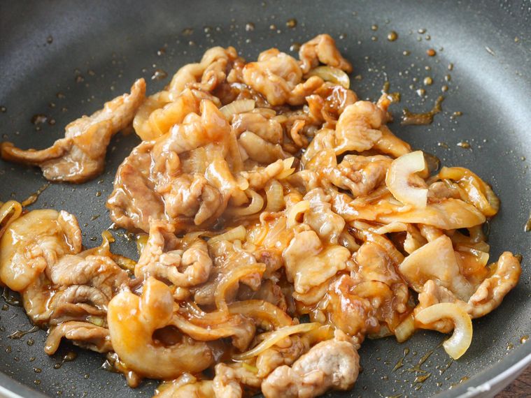 炒めた豚肉玉ねぎにに調味料で味付けする
