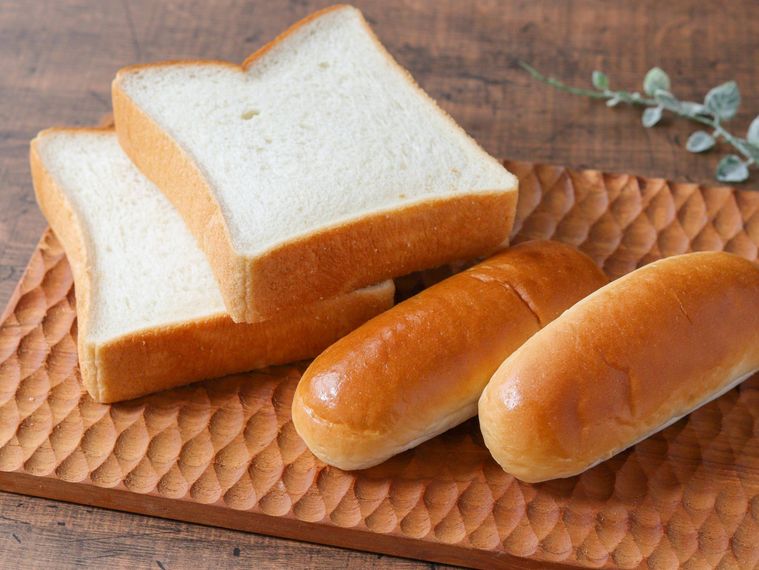 食パンとロールパンが木のトレイに置かれている