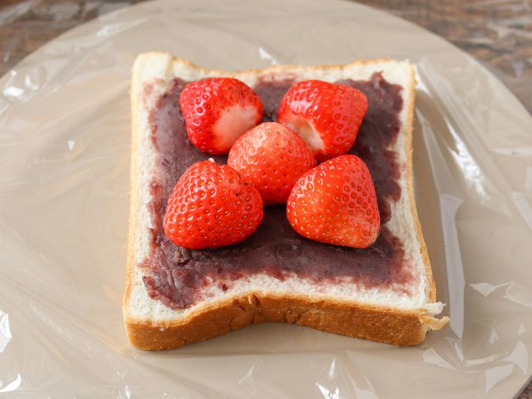 こしあんをぬった食パンにいちごを並べている。