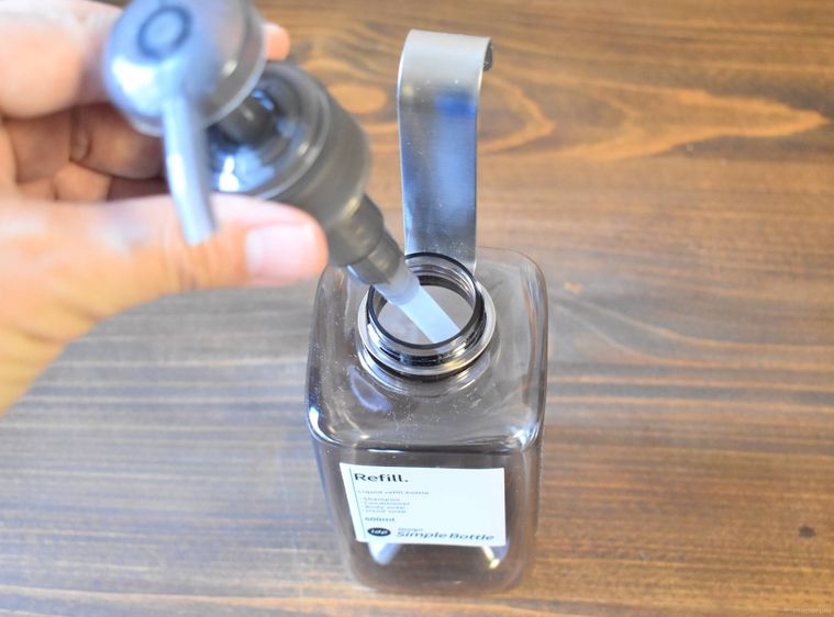 ステンレスボトルハンギングフックにシャンプーボトルを設置する様子