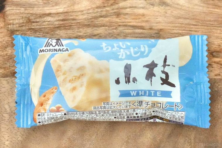 木のカッティングボードにのった水色のパッケージのホワイトチョコレート菓子