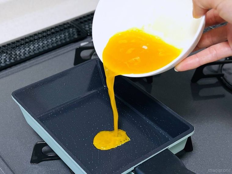 フライパンに卵液を流し込んでいる様子