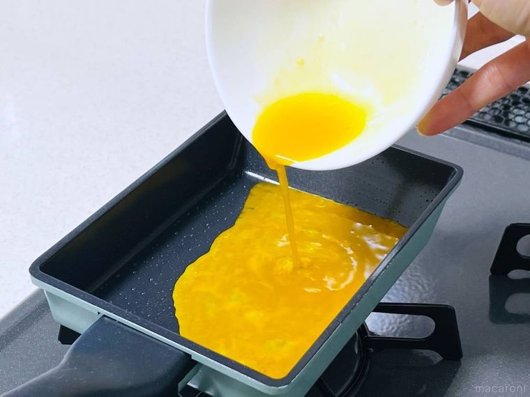 フライパンに卵液を流し込んでいる様子