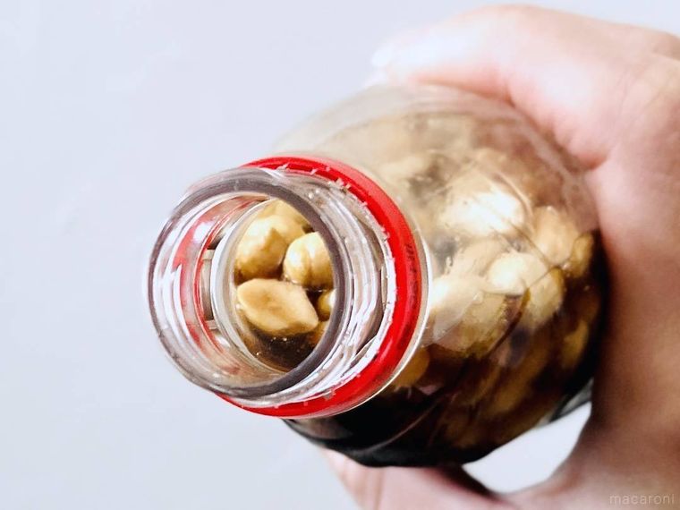 ピーナッツが入ったコーラのボトルを傾けている様子