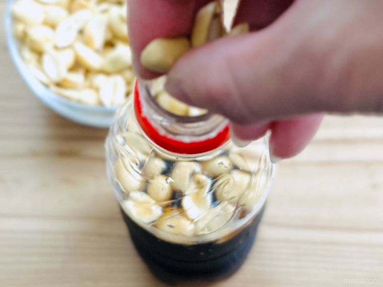 コーラのボトルにピーナッツを入れている様子