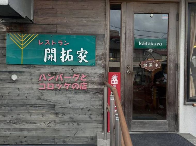 グリーンの看板が掲げられたレストラン開拓家の外観