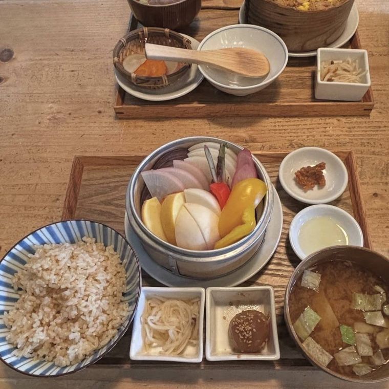 木のお盆にのった蒸し野菜とご飯と味噌汁