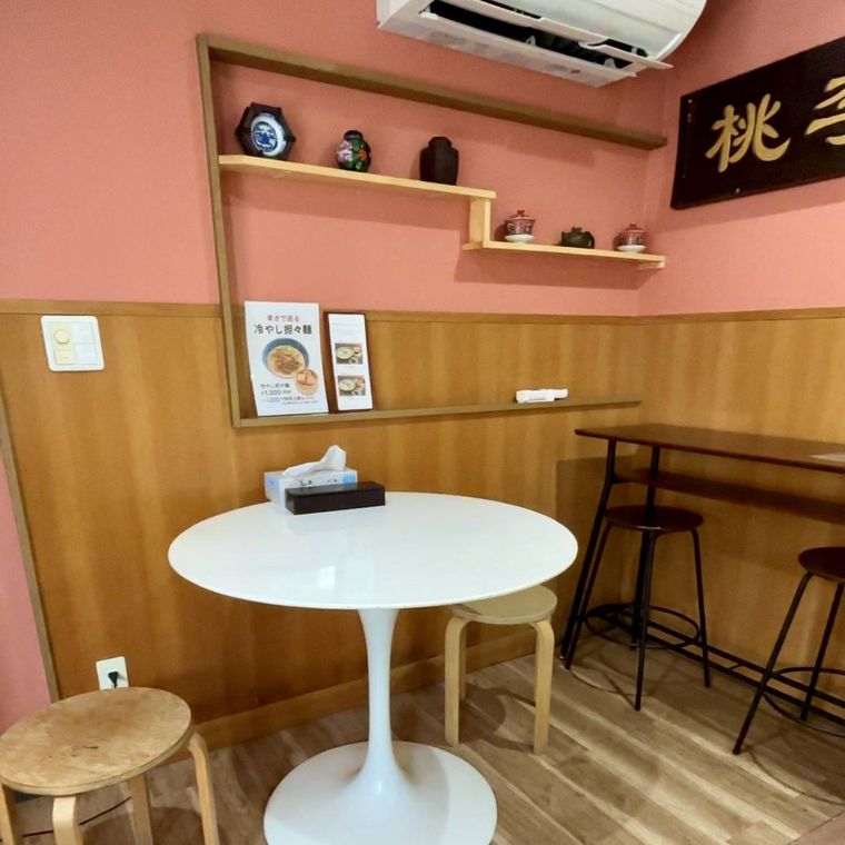 サーモンピンクの壁に上海の陶器、白いテーブルが並ぶ店内