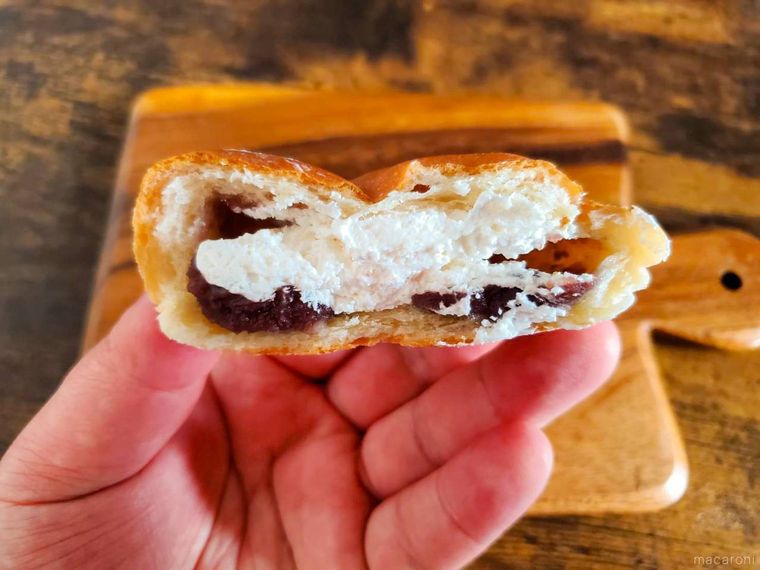 半分に割ったファミリーマートもっちり食感ホイップあんぱんを手で持っている様子